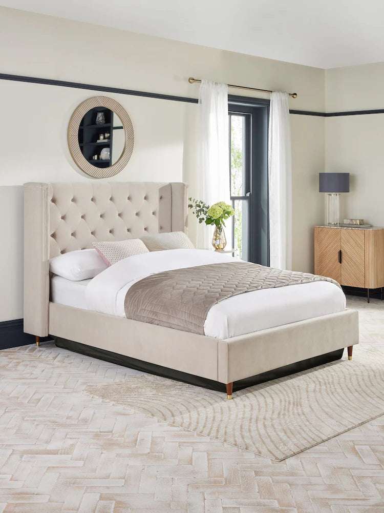 A fully upholstered LunaRest bed with a beige headboard featuring buttoning and winged sides, placed in a contemporary bedroom setting.