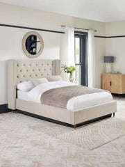 A fully upholstered LunaRest bed with a beige headboard featuring buttoning and winged sides, placed in a contemporary bedroom setting.