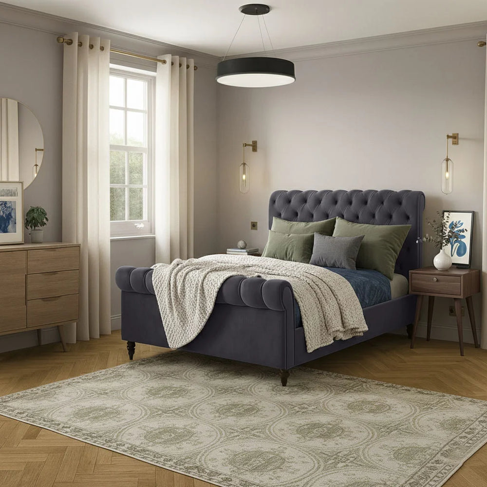Neatly arranged bedroom with a purple bed, green pillows, and wooden furniture.