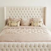 The Astoria Cream Velvet Bed Frame with deep diamond tufted wingback headboard, champagne quilted bedding, and luxury metallic pillows – straight front view