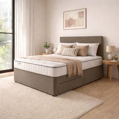 Beige bed with pillows and a blanket in a bedroom setting.