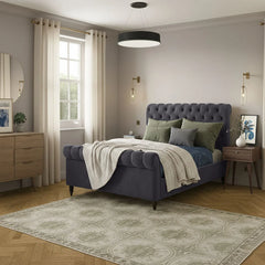 Neatly arranged bedroom with a purple bed, green pillows, and wooden furniture.