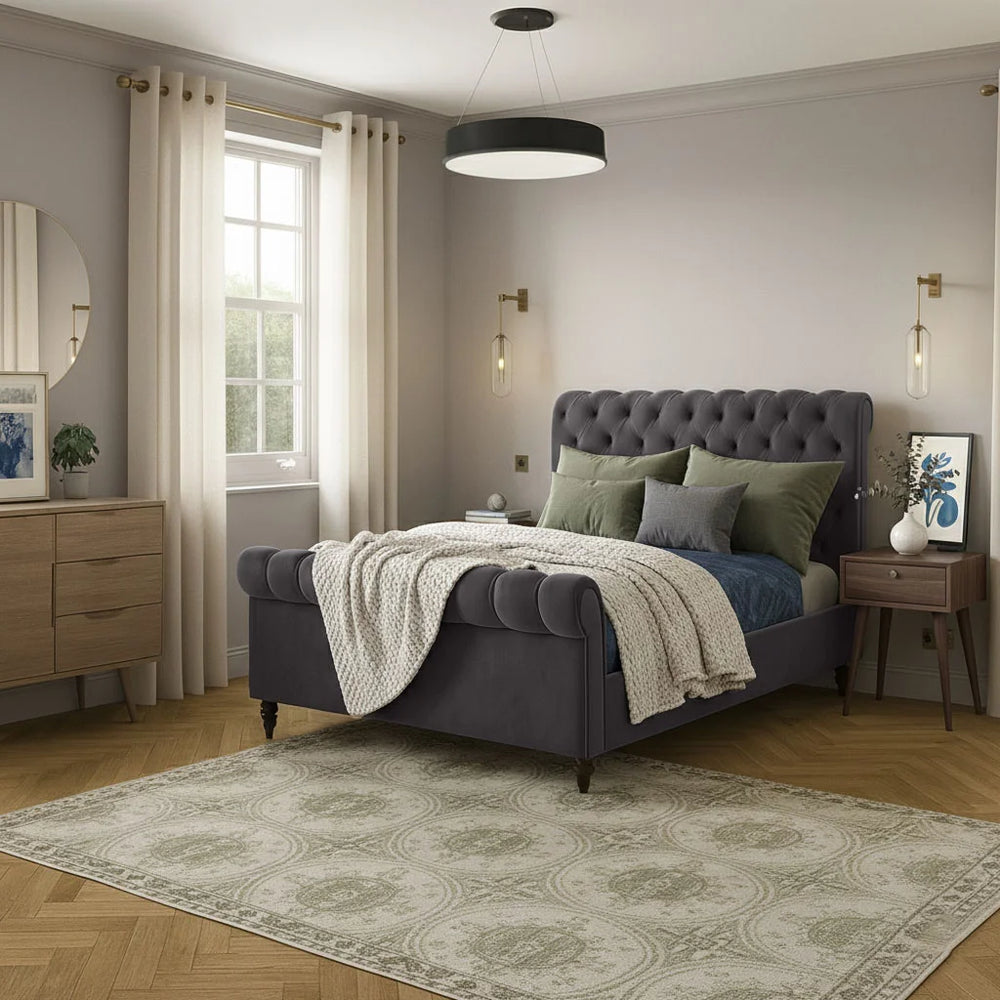Neatly arranged bedroom with a purple bed, green pillows, and wooden furniture.