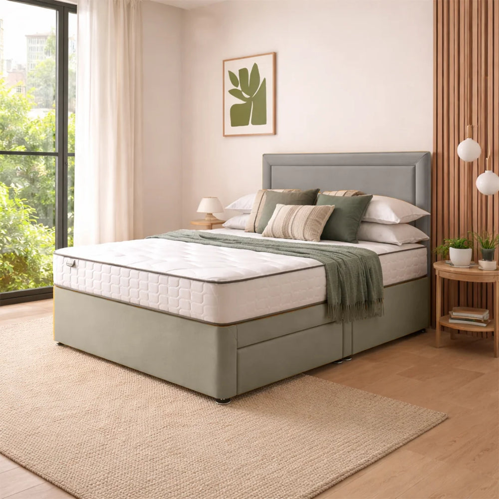 Gray upholstered bed with white mattress in a bright bedroom with large windows.